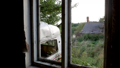 Panning-shot-through-the-window-of-an-abandoned-house