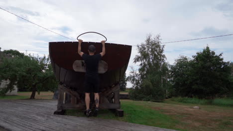 Mann-Trainiert-Auf-Einem-Alten-Holzboot