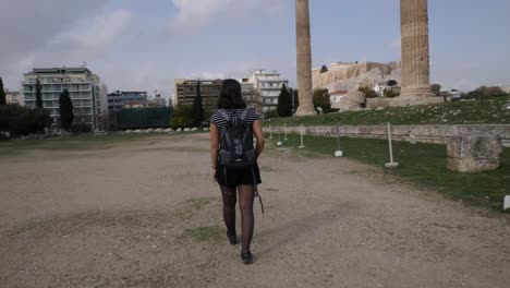 Young-asian-tourist-walks-and-turns-around-at-an-ancient-pillar-in-Athen