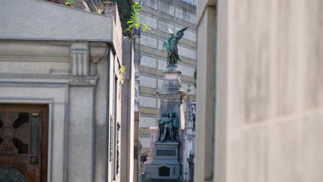 Angel-and-Three-men-holding-flag-mausoleum-statue-in-La-Recoleta-Cementery-at-daytime-long-shot-tilt-down-to-high
