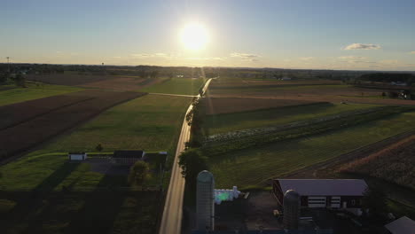 Drone-shot-of-farmhouses-and-farmland-as-the-gorgeous-golden-sun-sets-in-the-distance