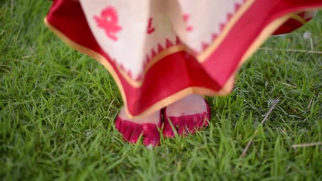 Füße-Einer-Frisch-Verheirateten-Indischen-Frau-Kommen-Und-Bleiben-Auf-Gras-Stehen,-Füße-Mit-Alta-Oder-Roter-Farbe