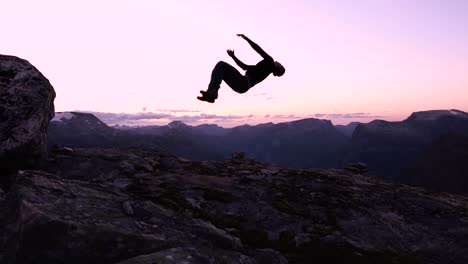 Man-doing-a-backflip-during-beautiful-sunset-in-slow-motion,-living-life-to-the-fullest