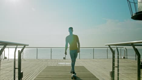 Young-attractive-man-skateboarding-on-Bridge-in-the-morning