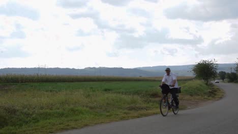 Un-Hombre-Monta-Su-Bicicleta-En-Un-Camino-Rural