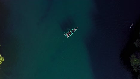 AERIAL:-Lago-De-Camecuaro,-Boat,-Swimmer,-Tangancicuaro,-Mexico