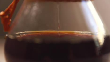 Dripping-coffee-into-container-looking-at-the-bottom-of-a-glass-container-when-you-see-a-stream-of-coffee-dripping-through-a-white-natural-filter-on-the-bottom-press-capture-in-slow-motion-at-120-FPS