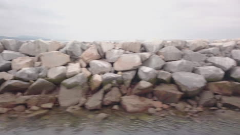 Flying-along-a-rocky-seawall-in-Southern-California-on-an-overcast-afternoon