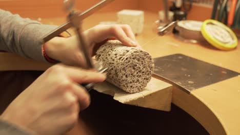 Close-up-of-cutting-concrete---geo-polymer-cylinder-with-string-saw---shot-from-workroom-in-slow-motion