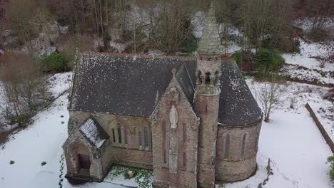 Aerial-footage-of-St-Palladius-Church-in-the-snow-on-a-winter-day-in-Aberdeenshire,-Scotland