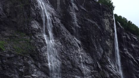 Paisaje-Noruego,-Gran-Cascada-De-Cerca-Bajando-Por-Las-Rocas-Con-Bosque-Verde-Debajo
