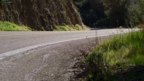 Eine-Person,-Die-Auf-Einem-Motorrad-In-Voller-Roter-Schutzausrüstung-Auf-Einer-Bergstraße-In-Der-Wüste-Kaliforniens-Unterwegs-Ist