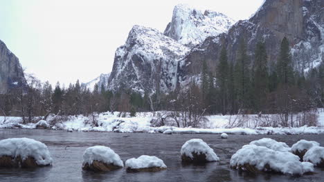 Wide-shot-Yosemite's-Bridal-Veil-Falls-in-the-snow-with-Merced-river-in-the-foreground