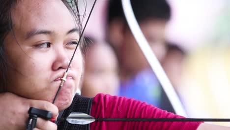 Young-asian-girl-aiming-carefully-with-archery-during-a-practice-session