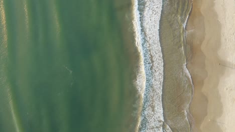 Wunderschöne-Drohnen-Filmaufnahme-Von-Oben,-Die-Bei-Sonnenaufgang-über-Das-Meer-Eines-Brasilianischen-Strandes-Mit-Weißem-Sand-Und-Smaragdgrünem-Klarem-Wasser-Schwenkt