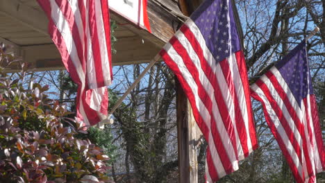 Amerikanische-Flaggen-Hängen-Von-Der-Veranda-Eines-Alten-Hauses