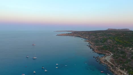 Drone-views-of-world-famous-Konnos-Beach-in-Mediterranean-island-of-Cyprus-late-afternoon-after-sunset-with-clear-turquoise-sea-water