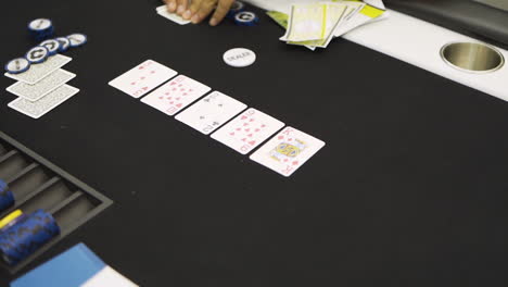 Dealer-handing-out-cards-at-a-poker-table