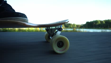 Close-side-view-to-a-wheels-of-the-skateboard-while-riding-through-the-park