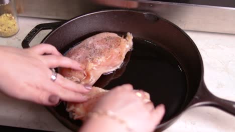Putting-the-already-prepared-filled-chicken-breasts-in-forged-pan