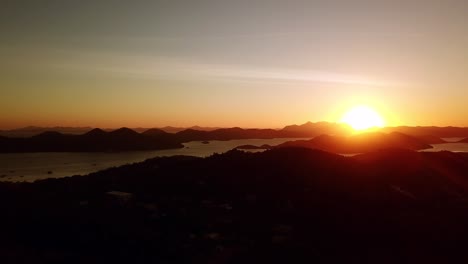Aerial-drone-shot-of-beautiful-sunset-with-vista-of-ocean,-islands-and-mountains,-in-Palawan,-Philippines