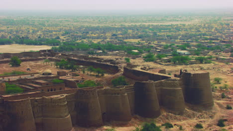 Aerial-flight-over-the-The-historically-significant-Derawar-fort,-Enormous-and-impressive-structure-in-the-heart-of-the-Cholistan-desert,-Located-south-of-the-city-of-Bahawalpur,-Pakistan