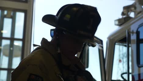 Silhouette-Eines-Feuerwehrmanns-Neben-Einem-Feuerwehrauto,-Das-Für-Den-Ersten-Einsatz-Bereit-Ist