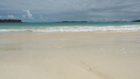 A-beautiful-Tropical-seascape-of-Bermuda's-clear-blue-water,-and-calm-waves-crashing-on-to-the-sand