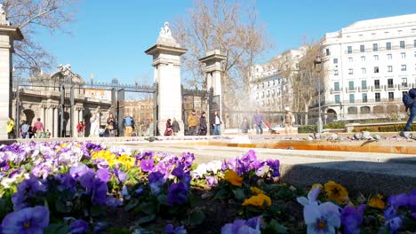 Menschen-Betreten-Das-Tor-Zum-Retiro-Park,-Madrid,-Mit-Puerta-De-Alcála-Im-Hintergrund,-Zeitlupe