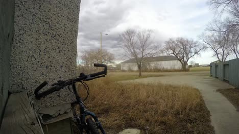 TIME-LAPSE---Old-bicycle-leaning-against-a-house-in-the-front-yard-of-a-house-in-the-country-as-the-clouds-fly-by