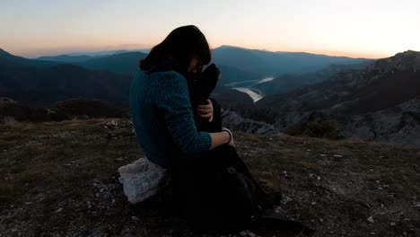 Mädchen-Kuschelt-Schwarzen-Labrador-Hund-Auf-Einem-Berg