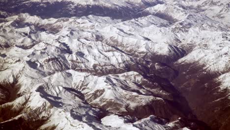 Aerial-plane-view-of-snow-covered-mountain-peaks-of-Alps-and-Alpine-valleys