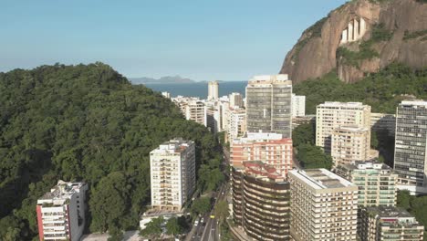 Langsame-Seitliche-Luftbewegung-Nach-Links-Mit-Blick-Auf-Wohnhochhäuser-Mit-Einem-Berg-Dahinter,-Der-Einen-Durchgang-Zwischen-Dem-Viertel-Copacabana-In-Rio-De-Janeiro-Freigibt