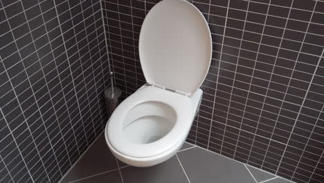 Toilettenschüssel,-Toilette-Im-Modernen-Badezimmer-Mit-Schwarzen-Und-Grauen-Fliesen,-HD-1080p,-Offener-Deckel,-Schwenk