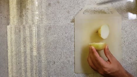 Man-hands-cutting-onion-in-two-parts