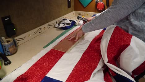 Woman-prepares-to-remove-excess-material-on-a-handmade-quilt-to-ready-the-quilt-for-binding