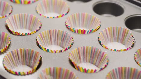 Placing-cupcake-paper-liners-onto-a-backing-tray