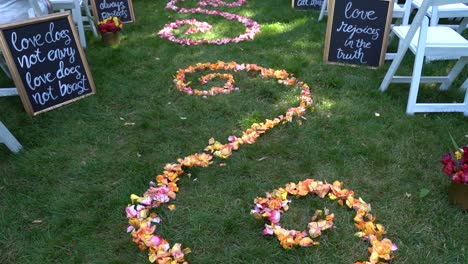 Pre-Service-Outdoor-Garden-Wedding-Aisle-Decorated-with-Flower-Petals-Arranged-in-Twirl-Design-and-Bible-Verses