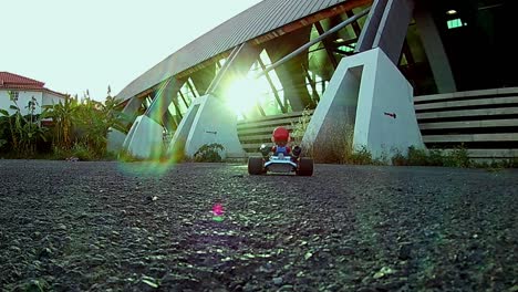 Close-up-of-RC-radio-controlled-Super-Mario-theme-racing-KART-taking-off-on-a-real-asphalt-road-on-a-sun-shining-day