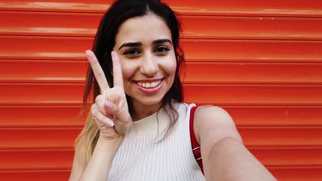 Schönes-Junges-Mädchen-Macht-Selfie-Mit-Smartphone-Vor-Orangefarbenem,-Rotem-Hintergrund