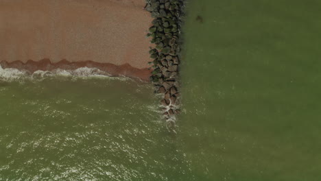 Aerial-shot-of-a-beach-defending-from-high-too-low