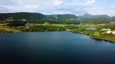 Aerial-slidling-landscape-shot-of-coast-of-lake-velenjsko-with-hills-in-the-background-slovenia-europe