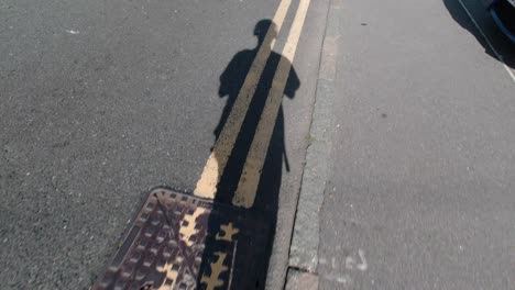 Teenager-filming-his-shadow-while-walking-during-a-sunny-day
