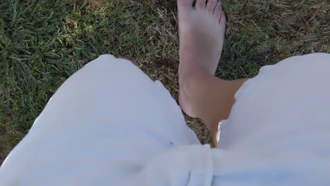 Pov-view,-Man-with-Bermuda-shorts-and-barefoot-walking-on-dry-grass