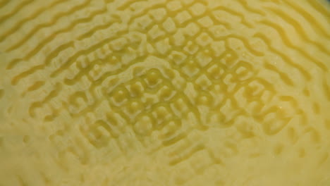 Makroaufnahme-Einer-Gelben-Flüssigkeit-Von-Oben,-Die-Sich-Bewegt-Und-Verschiedene-Zymatische-Muster-Bildet
