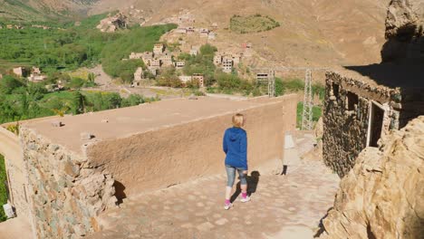Blonde-tourist-girl-exploring-Moroccan-rural-houses-in-Imlil,-High-Atlas,-Morocco