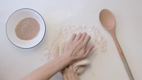 Top-view-of-a-hands-in-a-minimal-white-table-kneading-dough