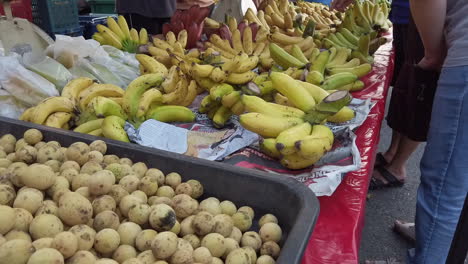 Lanzonen-Und-Bananenfrüchte-Werden-Zusammen-Mit-Verkäufer-Und-Käufer-Auf-Dem-Tisch-Ausgestellt