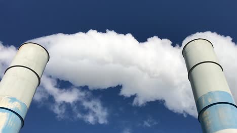 Weiße-Rauchwolken-Aus-Zwei-Industrieschornsteinen-Vor-Blauem-Himmel