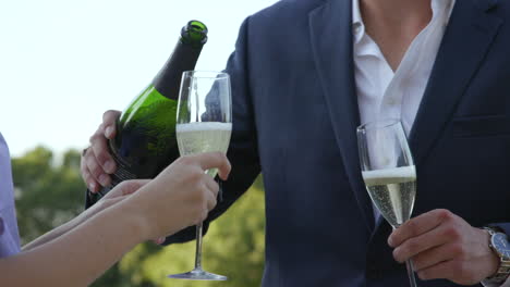A-young-couple-celebrates-by-pouring-a-bottle-of-champagne-in-slow-motion
